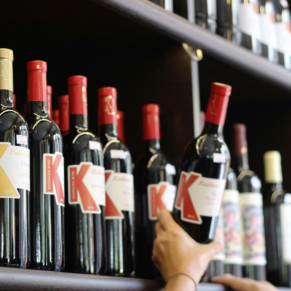 a customer taking a wine bottle from the shelf