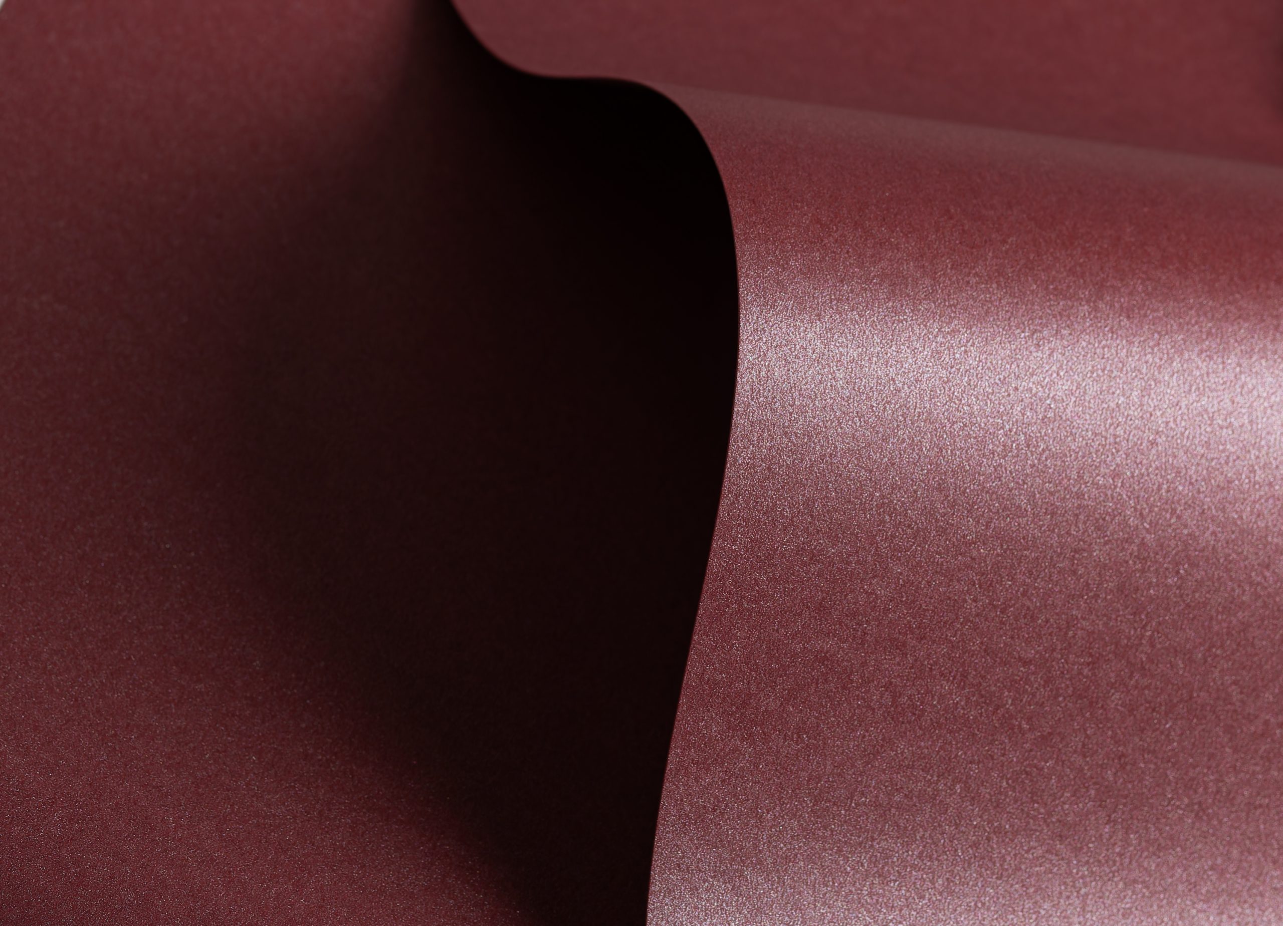Close-up of burgundy packaging material showing subtle gloss texture
